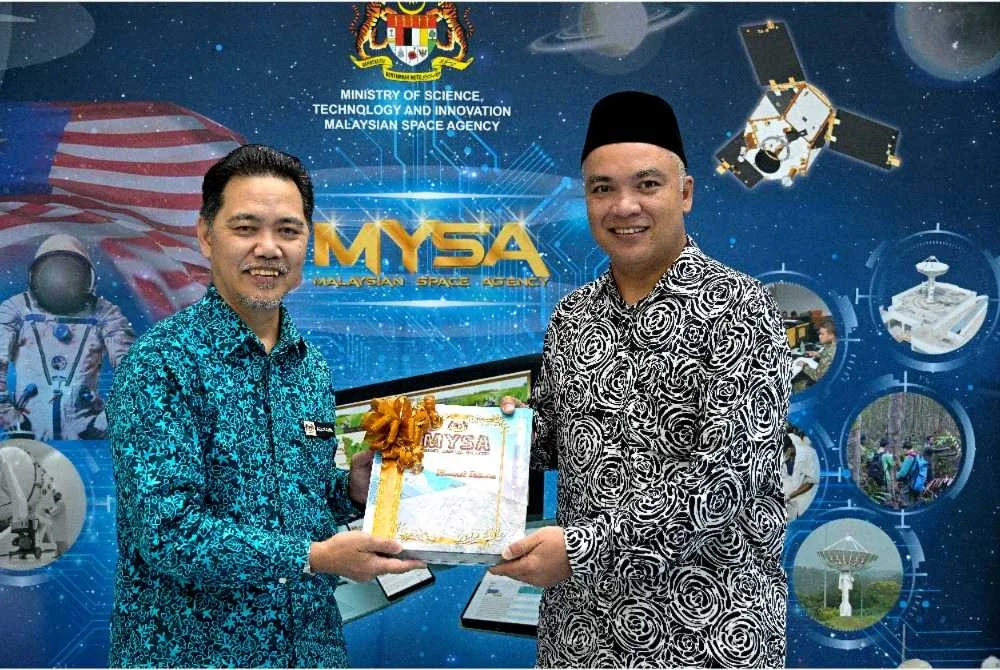 Ahli Parlimen Padang Besar, Rushdan Rusmi (kanan) menyampaikan cenderamata kepada Ketua Pengarah Agensi Angkasa, Azlikamil Napiah,