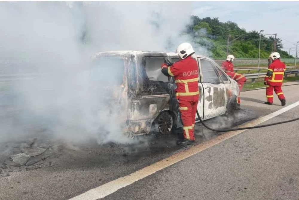 Anggota bomba sedang memadamkan kebakaran sebuah MPV di sini pada Jumaat.