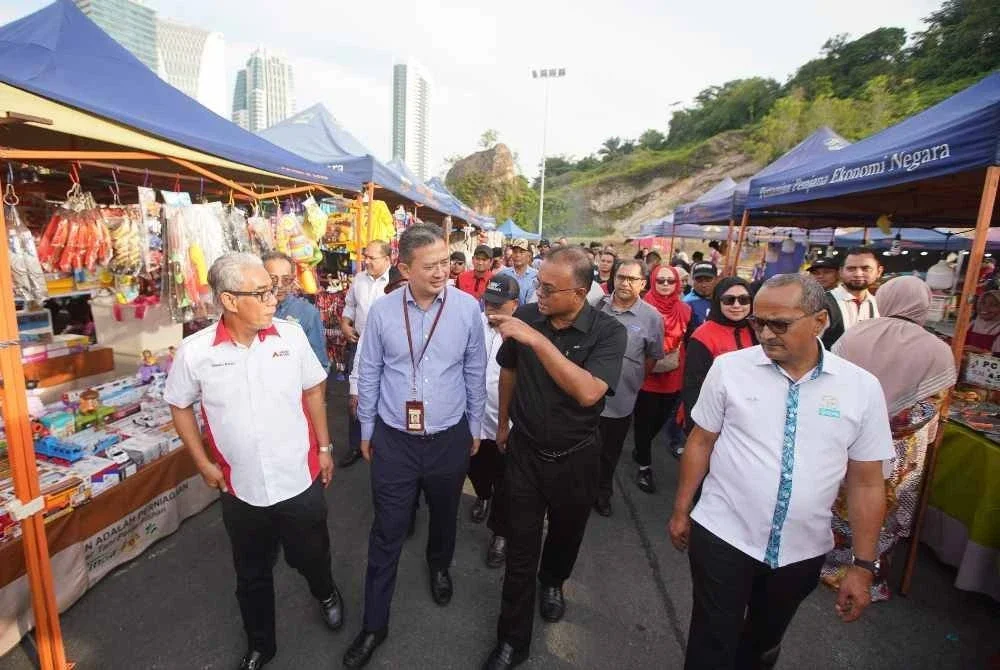 Isham (dua dari kanan) Ishak bersama (kiri) Ahmad Badli Shah ketika melawat Pasar Tani pada program Lawatan Pasar Tani Putrajaya pada Jumaat.