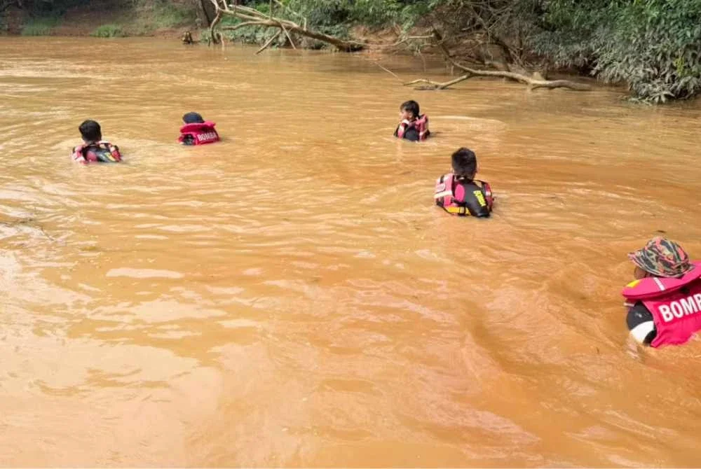 Pasukan penyelamat berusaha mengesan mangsa yang dikhuatiri lemas di Jalan Jabor-Paka berhampiran Bandar Al Muktafi Billah Shah (AMBS), Dungun pada Jumaat.