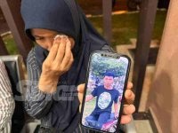 Raja Ruhana mengesat air mata ketika menunjukkan gambar anaknya. 