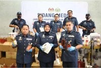 Noraidah (tengah) menunjukkan antara rampasan barang kes hasil tindakan ke atas sindiket memproses minuman keras dan penyeludupan produk tembakau. Foto: JKDM KUALA LUMPUR