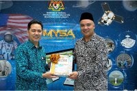 Ahli Parlimen Padang Besar, Rushdan Rusmi (kanan) menyampaikan cenderamata kepada Ketua Pengarah Agensi Angkasa, Azlikamil Napiah,