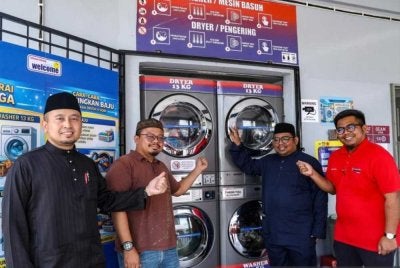Mohamad Shafwan (kanan) menunjukkan perkhidmatan dobi yang merupakan inisiatif di bawah program SejaTi Madani. - Foto: Bernama