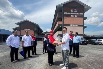 Kah Woh mengadakan lawatan ke ke sekolah di Johor. Foto: FB SK Sungai Tiram