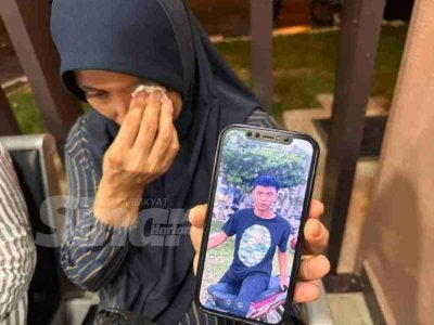 Raja Ruhana mengesat air mata ketika menunjukkan gambar anaknya. 