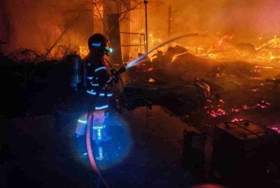 Anggota bomba sedang memadamkan kebakaran sebuah kilang kayu, pada Jumaat.