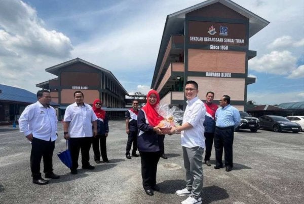Kah Woh mengadakan lawatan ke ke sekolah di Johor. Foto: FB SK Sungai Tiram