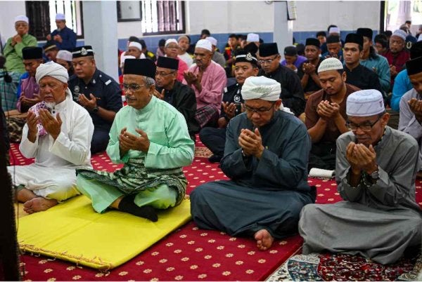 Undang Luak Rembau Datuk Sedia Raja Hassan Ab Hamid (dua, kiri) mengaminkan bacaan doa ketika solat Jumaat di Masjid Kampung Paya Seberang, hari ini. Foto Bernama 