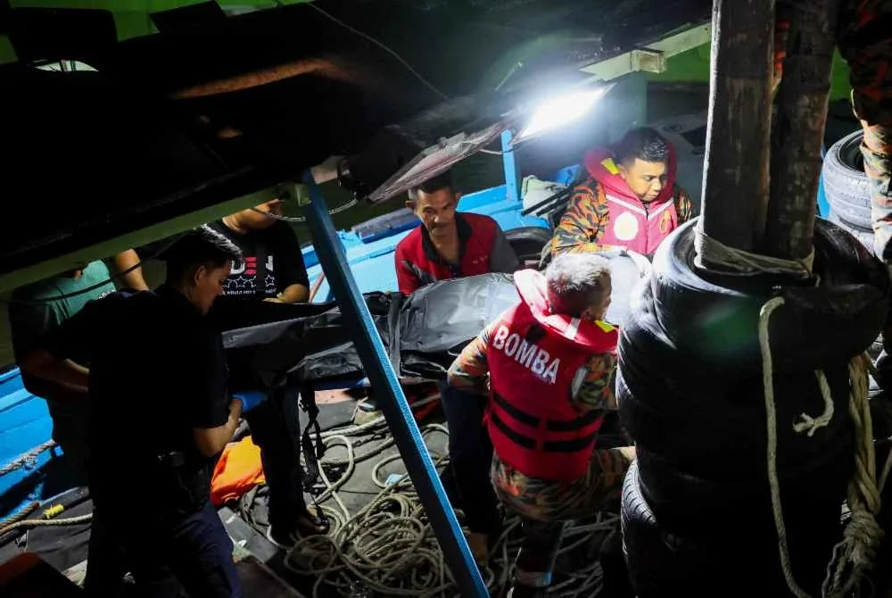 Pasukan penyelamat mengusung jenazah kru bot, Ahmad Nasaruddin Mohmad Jalil, 37, yang maut selepas bot mencandat sotong dinaikinya karam kira-kira sembilan batu nautika dari Kuala Nerus di Jeti LKIM Kampung Batin. Foto Bernama