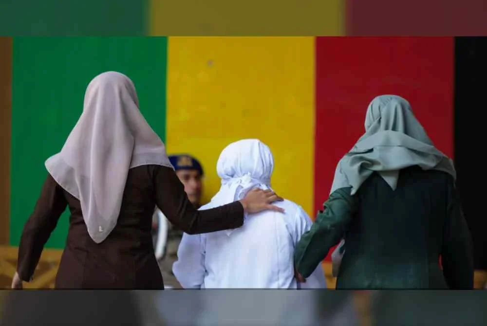 Seorang wanita diiringi pegawai penguat kuasa syariah selepas menjalani hukuman sebat di khalayak ramai di Banda Aceh, kerana didapati bersalah melanggar undang-undang syariah dengan bercium bersama seorang lelaki yang bukan suaminya ketika siaran langsung di TikTok. Foto AP
