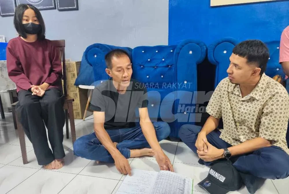 Nur Arissa (duduk) bersama ayahnya (tengah) ketika menerima kunjungan daripada pertubuhan bukan kerajaan (NGO) di rumah di Kampung Cengal Lempung di sini.