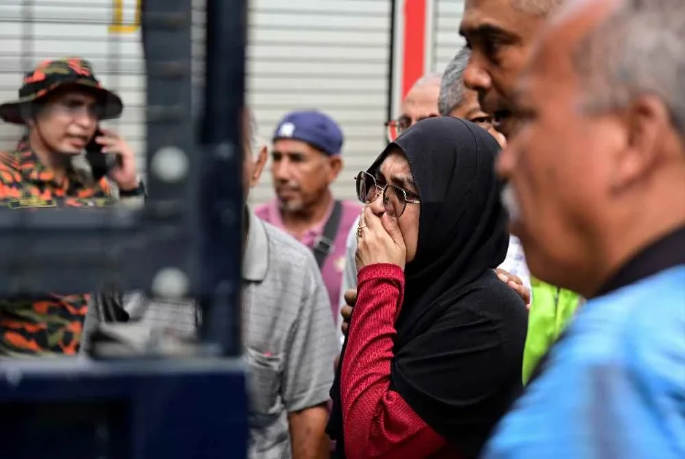 Ahli keluarga tidak dapat menahan kesedihan setelah seorang wanita ditemukan selepas terjatuh dari jambatan Sungai Paka di Jalan Jabor-Paka berhampiran Bandar Al Muktafi Billah Shah. Foto Bernama