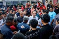 Anwar (tengah) diiringi Mohammed Taufiq bersalaman dengan orang ramai yang hadir pada Program Jalinan Mesra PMX Bersama Belia Johor sempena Kembara Inspirasi Belia Akar Umbi (KIBAR) di Taman Melor, Tampoi pada Sabtu. Foto Bernama