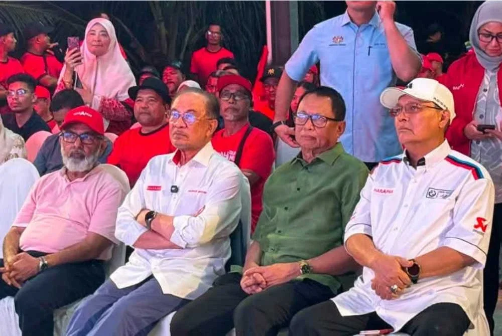 Mohd Puad (dua dari kanan) duduk bersebelahan Anwar pada program PH di Felda Ulu Tebrau Johor Bahru pada malam Sabtu. Foto FB Puad Zarkashi
