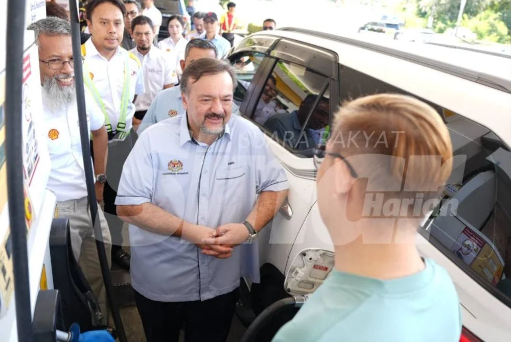 Amir Hamzah (dua dari kanan) menyapa pengguna yang mengisi diesel di sebuah stesen minyak di Jalan Sulaman, Kota Kinabalu.