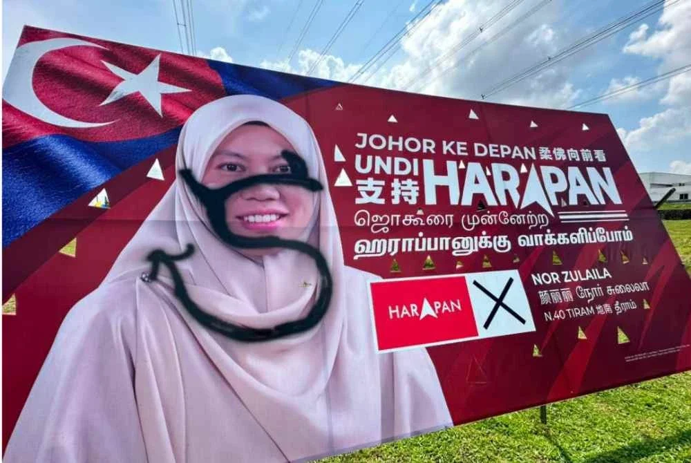 Papan iklan Nor Zulaila yang diconteng di Jalan Utama Kota Masai.