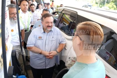 Amir Hamzah (dua dari kanan) menyapa pengguna yang mengisi diesel di sebuah stesen minyak di Jalan Sulaman, Kota Kinabalu.