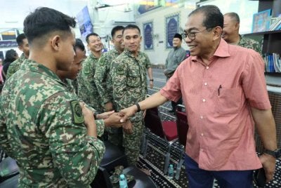 Mohamed Khaled menyantuni sebahagian anggota tentera selepas menyempurnakan pelancaran Program Ilmu dan Muafakat di Masjid Jamek Al-Faizin Felda Air Tawar 2 pada Ahad. Foto Bernama