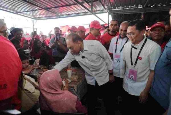 Nor Hafiz (dua dari kanan) bersama Anwar menyantuni penduduk di Simpang Renggam pada pagi Ahad. Foto FB Nor Hafiz