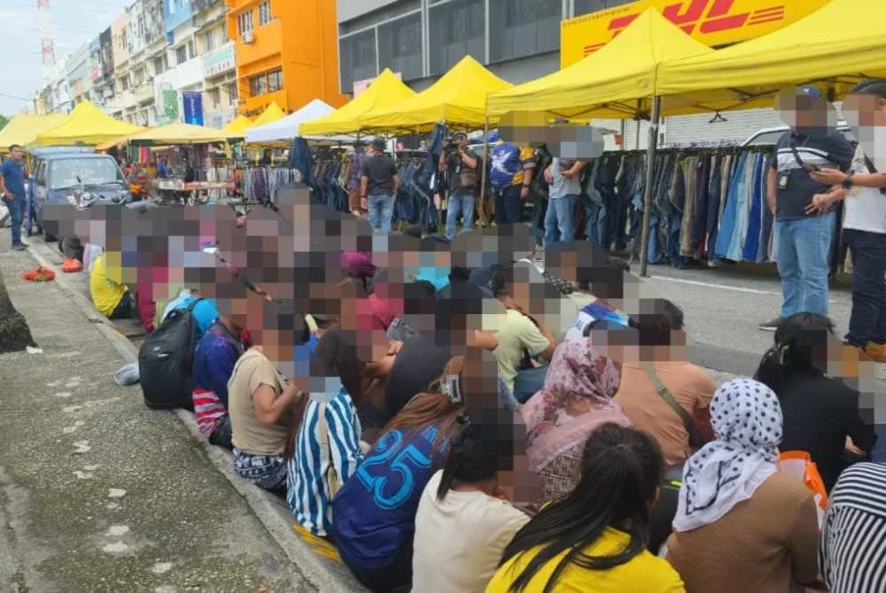Antara warga asing yang ditahan menerusi Op Kutip di sekitar pasar malam Taman Maluri, Kuala Lumpur pada Ahad.