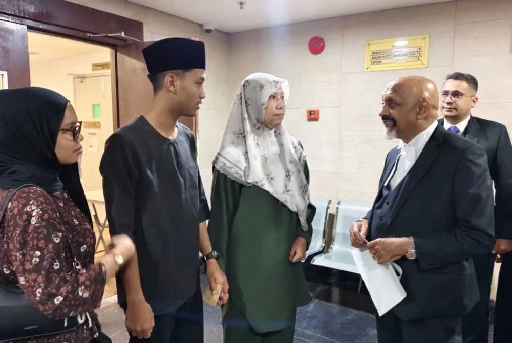 Nurhaswani Afni (kiri) bersama Naran Singh (kanan) sebaik selesai prosiding di Mahkamah Majistret Ipoh pada Isnin bagi pertuduhan melakukan kekerasan jenayah terhadap Sultan Perak, Sultan Nazrin Muizzuddin Shah ketika sambutan Hari Kebangsaan tahun lalu.