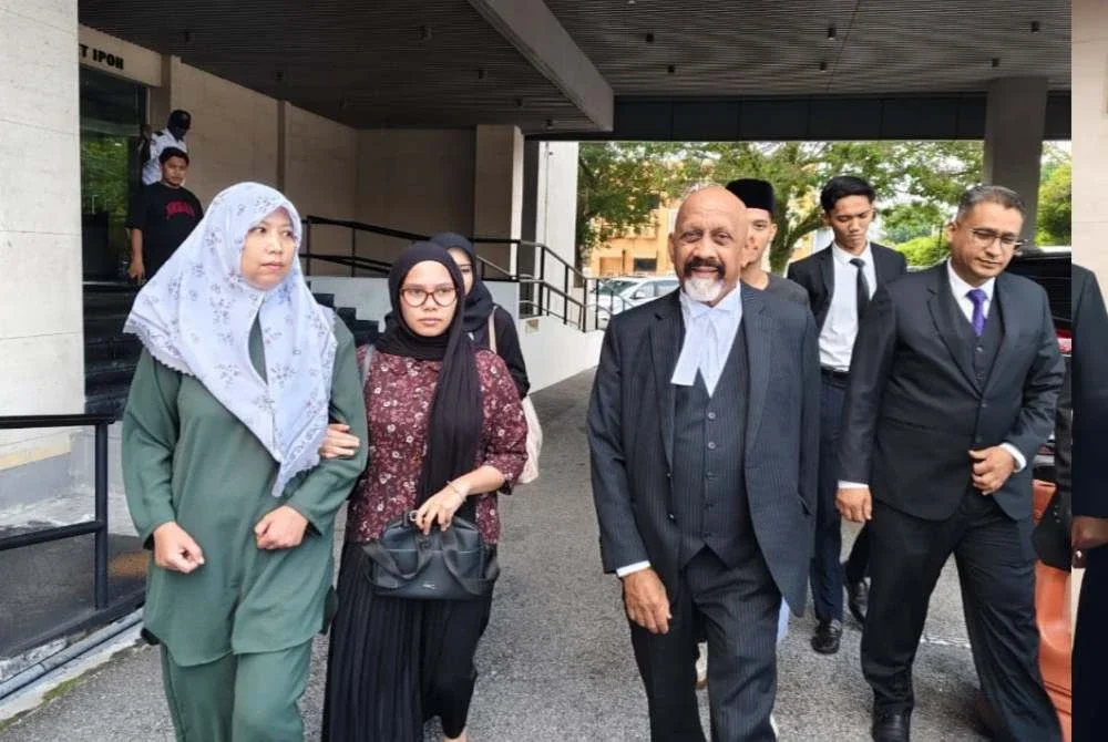 Nurhaswani Afni (kiri) bersama Naran Singh (kanan) sebaik selesai prosiding di Mahkamah Majistret Ipoh pada Isnin bagi pertuduhan melakukan kekerasan jenayah terhadap Sultan Perak, Sultan Nazrin Muizzuddin Shah ketika sambutan Hari Kebangsaan tahun lalu.