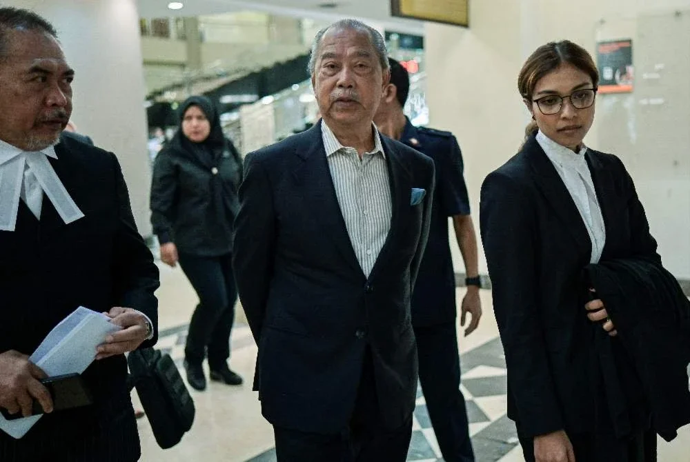 Muhyiddin (tengah) hadir bagi perbicaraan kes rasuah dan pengubahan wang haram yang melibatkannya di Mahkamah Tinggi pada Isnin. Foto: Bernama