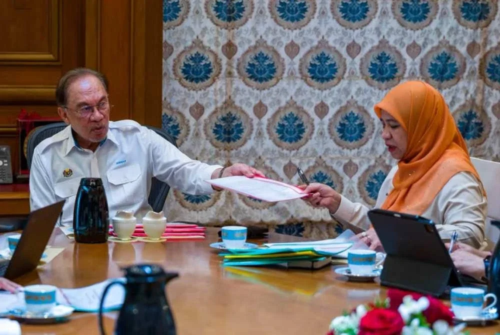 Anwar (kiri) menggesa Felda melipatgandakan usaha menyelesaikan isu yang sekian lama membelenggu warga peneroka. Foto FB Anwar Ibrahim
