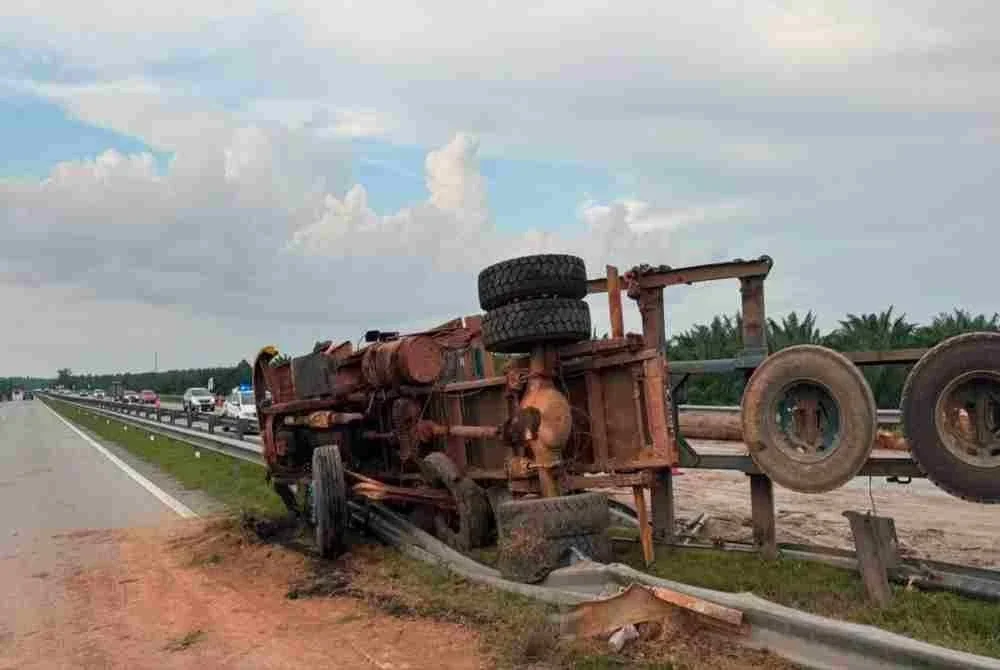 Keadaan lori balak yang terbalik menyebabkan muatan balak dibawa jatuh halang laluan. Foto Polis Maran