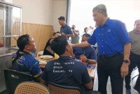 Mohamad (kanan) menyantuni pengundi DUN Tiram di Johor Bahru pada Ahad. 