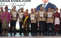 Saarani (depan, tengah) bersama Ahli-ahli Majlis Mesyuarat Kerajaan Negeri menunjukkan buku Laporan Kemajuan Tahun Keempat Perak Sejahtera 2030 yang turut dilancarkan di Pusat Konvensyen Casuarina di Ipoh pada Isnin.