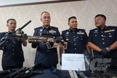 Mohd Alwi (dua dari kiri) menunjukkan laras senjata api tiruan yang dirampas bersama penahanan seorang lelaki dipercayai pengedar dadah di Sitiawan, Manjung, minggu lalu.