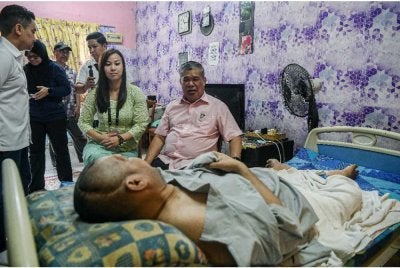 Mohamad Sabu (kanan) bersama calon PH bagi kerusi DUN Permas, Sharon Teo Siew Hui (kiri) menziarahi Suhaimi Hasan pada Program Ziarah Kasih DUN Permas. Foto Bernama