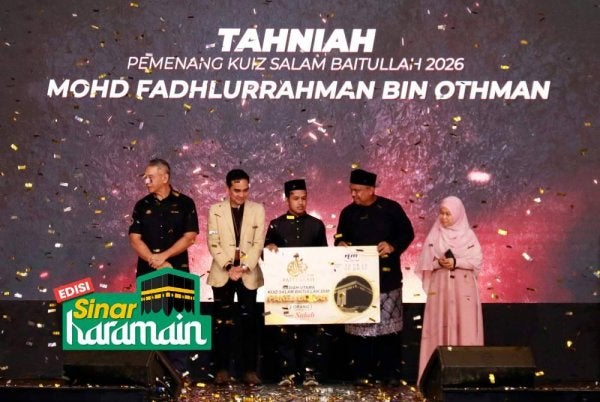 MOHD FADHLURRAHMAN (tengah) menerima hadiah utama kuiz Salam Baitullah yang disampaikan Ashwad. Foto MARDHIYYAH HOTEL & SUITES