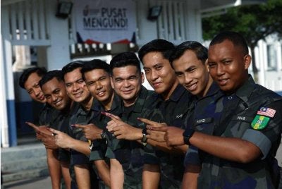 Anggota Pasukan Gerakan Am (PGA) menunjukkan jari berdakwat selepas menunaikan tanggungjawab mengundi awal bagi Pilihan Raya Negeri (PRN) Johor ke-16 di Kem PGA Batalion 5, Simpang Renggam hari ini. Foto Bernama
