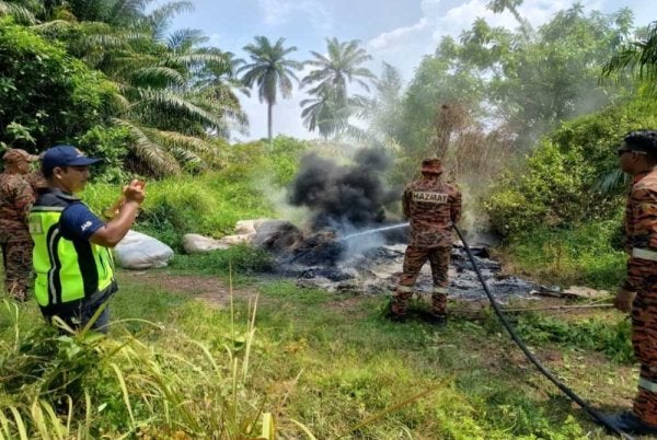 Pasukan bomba dipanggil untuk membantu memadam saki baki longgokan yang masih berasap. Foto JAS