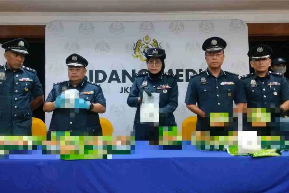 Wan Marini (tengah) menunjukkan bungkusan teh mengandungi dadah yang dicampakkan ke dalam laut di perairan Pulau Telur.