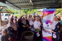 Maziah (kanan) bersama ahli Rumah Ngaji Teluk Muroh dan komuniti setempat bergotong-royong memasak bubur asyura dan bubur lambuk sempena 10 Muharam' baru-baru ini.