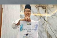 Abd Farid menunjukkan poster Program Nikah Jama'ie Syar'ie anjuran Masjid Negeri Perak bagi membantu pasangan yang ingin berkahwin di negeri ini.