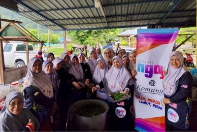 Maziah (kanan) bersama ahli Rumah Ngaji Teluk Muroh dan komuniti setempat bergotong-royong memasak bubur asyura dan bubur lambuk sempena 10 Muharam' baru-baru ini.