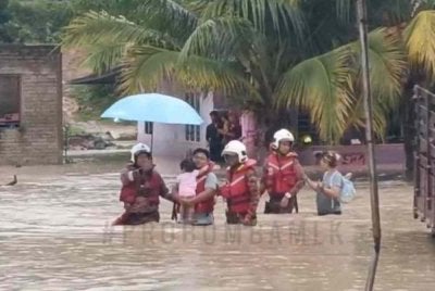 Antara penduduk yang dibantu pihak bomba untuk keluar dari lokasi banjir kilat. Foto JBPM Melaka