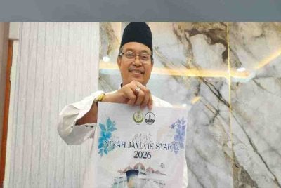 Abd Farid menunjukkan poster Program Nikah Jama'ie Syar'ie anjuran Masjid Negeri Perak bagi membantu pasangan yang ingin berkahwin di negeri ini.