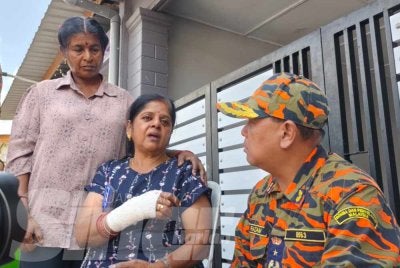 Pengarah Jabatan Bomba dan Penyelamat Malaysia (JBPM) Pahang, Datuk Mohd Razam Taja Rahim (kanan) bertanya sesuatu kepada Lomba selepas rumahnya di Taman Seri Mahkota Jaya terbakar pada pagi Rabu. 