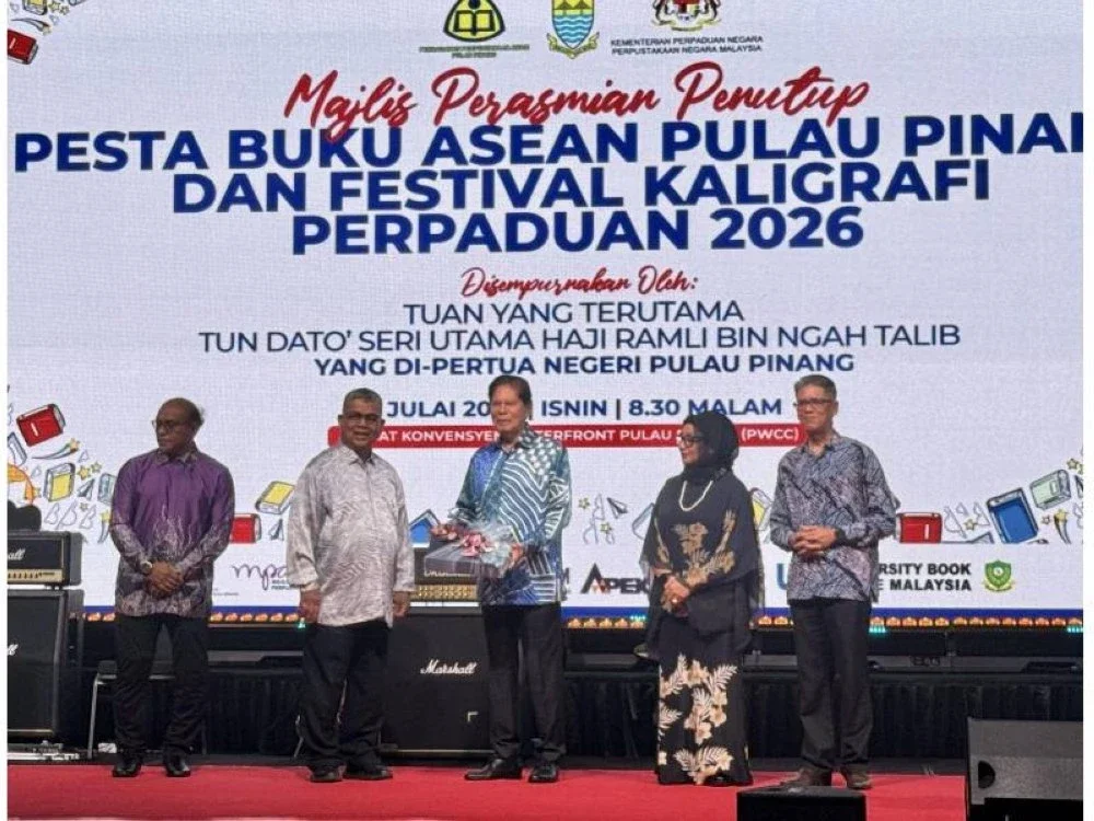 Ramli (tengah) menerima cenderahati daripada Aaron di Majlis Perasmian Penutup Pesta Buku ASEAN dan Festival Kaligrafi Perpaduan 2026.