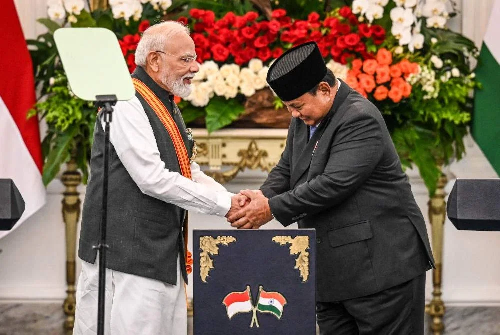 Narendra Modi (kiri) berjabat tangan dengan Presiden Indonesia, Prabowo Subianto, selepas menghadiri sidang akhbar bersama di Istana Merdeka, Jakarta. Foto: AFP