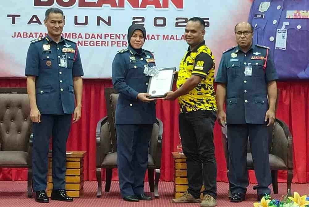 Sayani menyampaikan sijil penghargaan kepada Tok Batin Kampung Orang Asli Ampang Woh Batu 7, Bah Lilit Bah Batas sempena Majlis Perhimpunan Bulanan JBPM Perak di Ibu Pejabat JBPM Perak di Meru Raya pada Khamis.