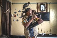 Magutha membelai beberapa ekor burung sebelum memberi makan di kediamannya di Kayole. Foto AFP