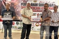 Mat Jusoh (dua dari kanan) yang menerima wang sumbangan disampaikan Dr Izani. Foto Adila Sharinni Wahid

