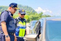 Mohd Misuari (kiri) memeriksa kenderaan pada Ops PeWA dan Ops Bersepadu Dadah terhadap kenderaan perdagangan di SPK JPJ Laloh, Kuala Krai pada Khamis.